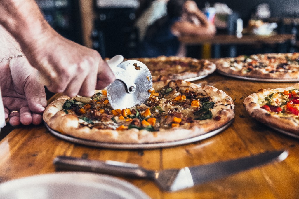 Stone L'Oven pizza being cut